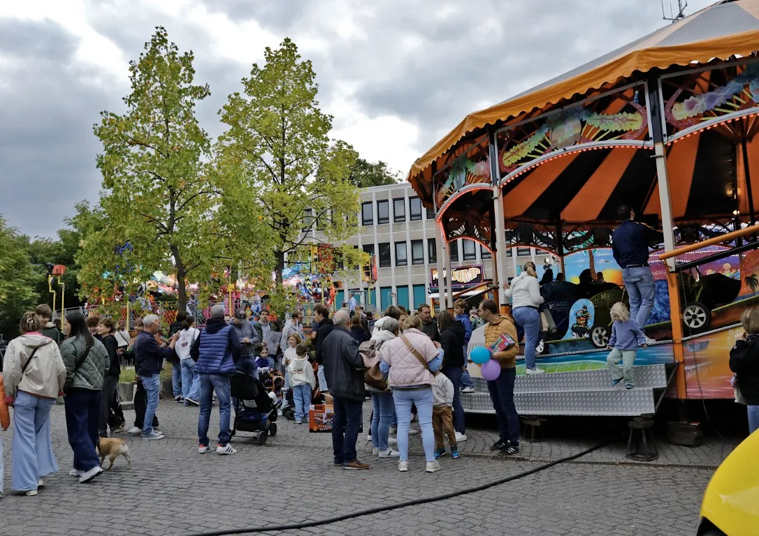 mensen en een attractie op de jaarmarkt van Rode